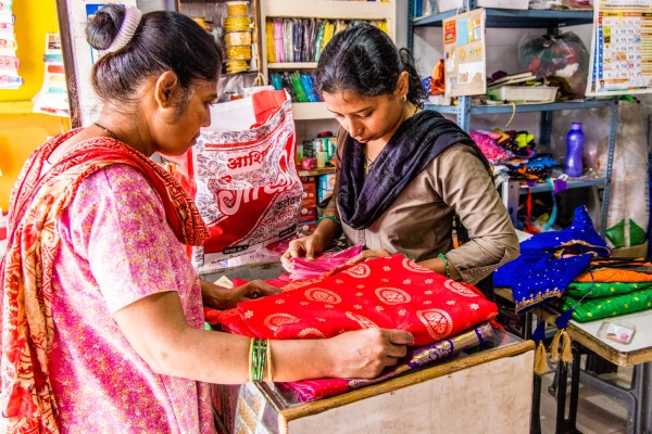 Supriya selecteert met haar klant materialen in haar winkel.